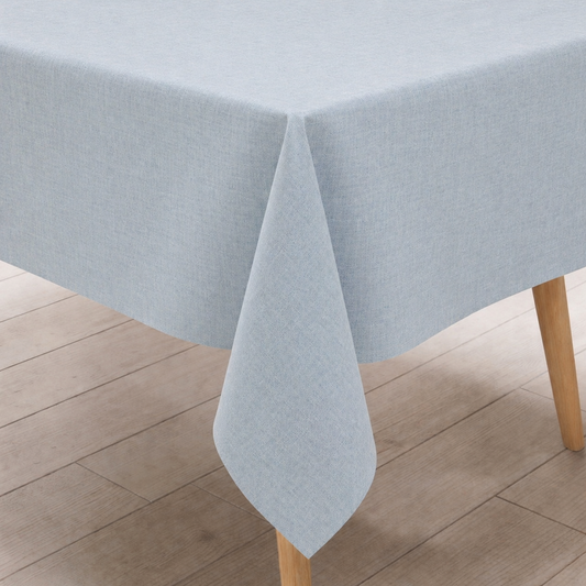  hellblaue Wachstuch-Tischdecke in dezenter Leinenoptik, drapiert über einen rechteckigen Tisch.