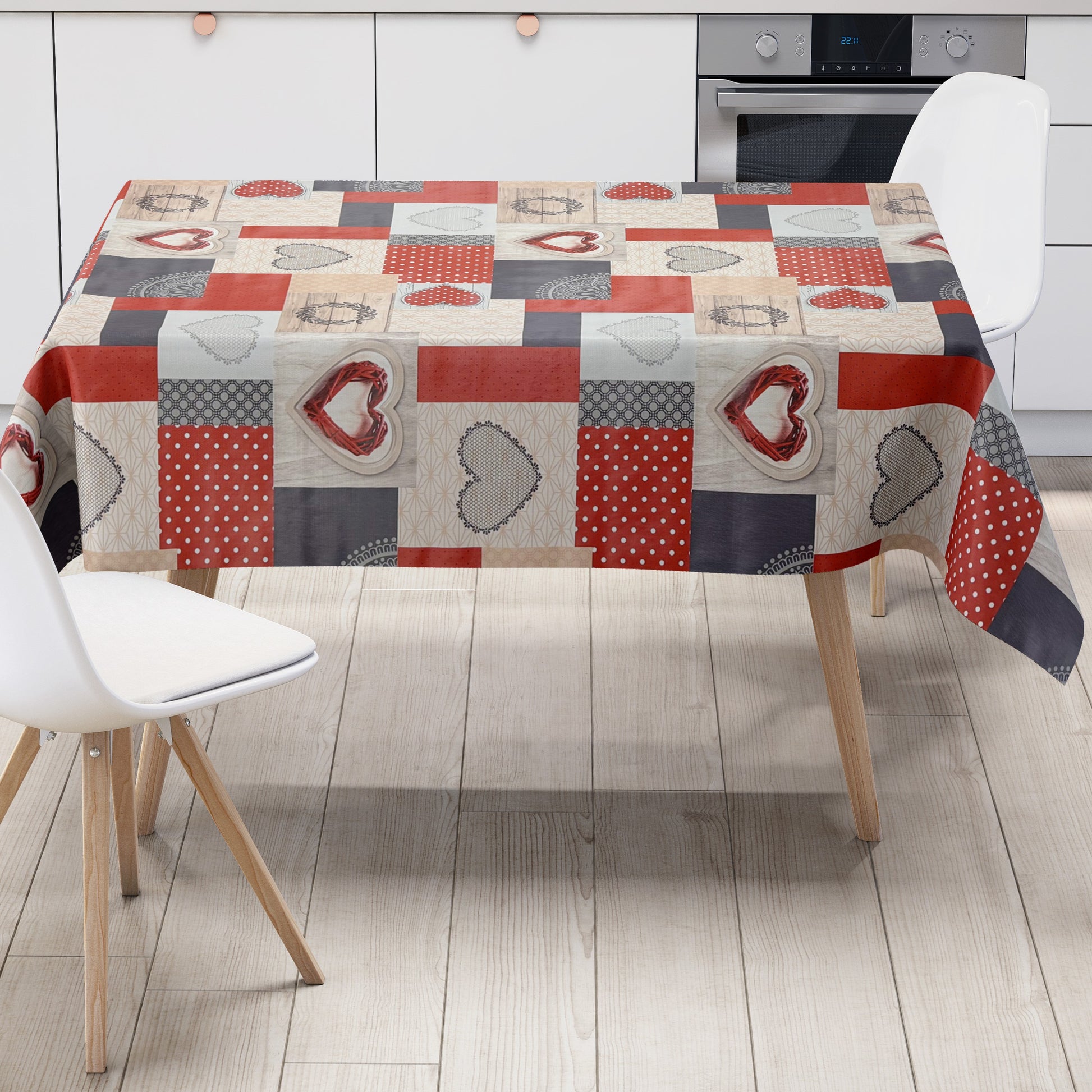 Wachstuch-Tischdecke im Patchwork-Design mit roten und grauen Herzmotiven, kombiniert mit Punkten, Holzoptik und grafischen Mustern