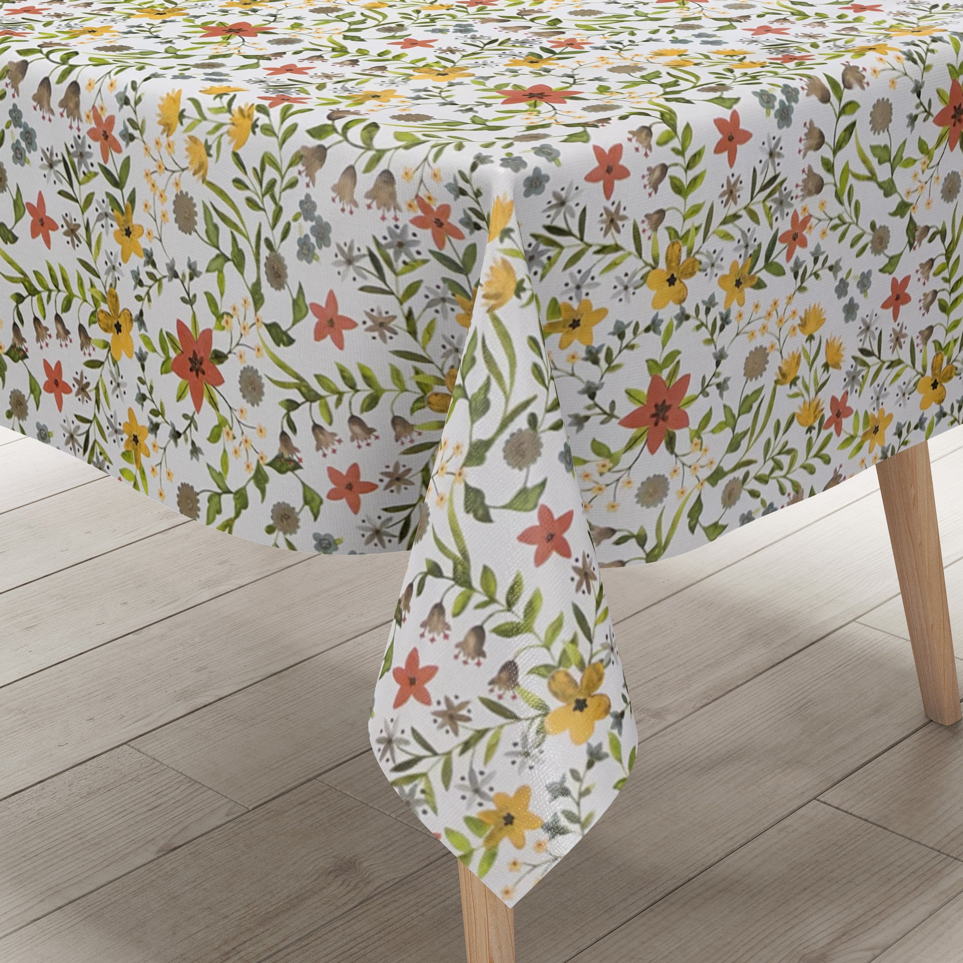 Weiße Wachstuch-Tischdecke mit zartem Blumenwiesen-Muster in Gelb, Apricot, Creme und Grau sowie grünen Blättern und Ranken in natürlicher Aquarell-Optik.