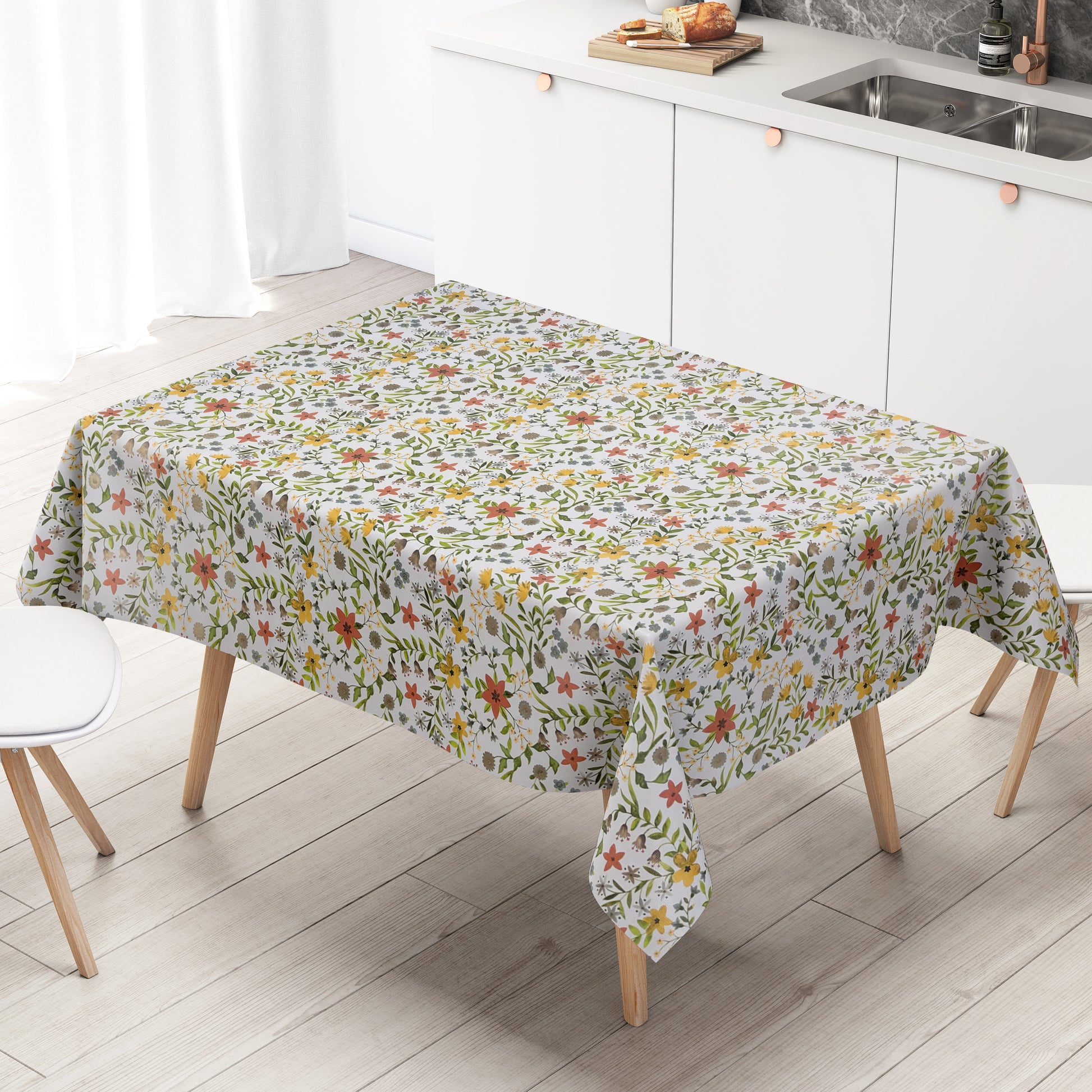 Weiße Wachstuch-Tischdecke mit zartem Blumenwiesen-Muster in Gelb, Apricot, Creme und Grau sowie grünen Blättern und Ranken in natürlicher Aquarell-Optik.