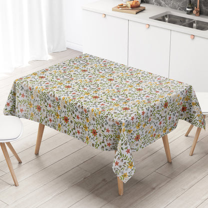 Weiße Wachstuch-Tischdecke mit zartem Blumenwiesen-Muster in Gelb, Apricot, Creme und Grau sowie grünen Blättern und Ranken in natürlicher Aquarell-Optik.
