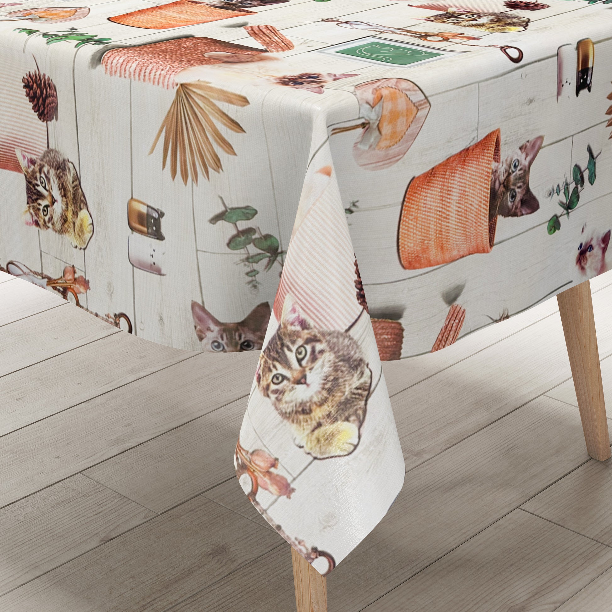Wachstuch-Tischdecke mit niedlichen Katzenmotiven, Körben, Pflanzen und dekorativen Naturdetails in warmen Beige- und Orangetönen auf heller Holzoptik.