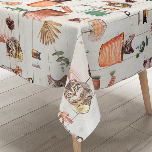 Wachstuch-Tischdecke mit niedlichen Katzenmotiven, Körben, Pflanzen und dekorativen Naturdetails in warmen Beige- und Orangetönen auf heller Holzoptik.