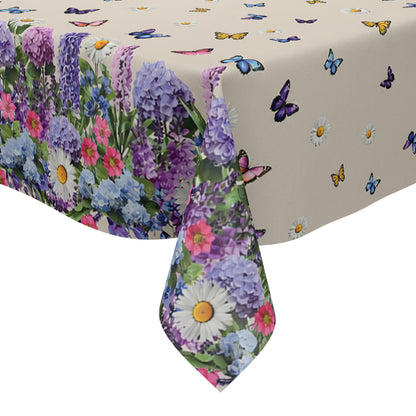Wachstuch-Tischdecke mit cremefarbenem Hintergrund, dekoriert mit bunten Schmetterlingen und weißen Margeriten. Entlang der Ränder verläuft eine üppige Blumenbordüre aus Lavendel, Hortensien und weiteren Blüten in Violett-, Blau-, Rosa- und Weißtönen. Das frühlingshafte Design erinnert an eine blühende Gartenwiese und sorgt für eine freundliche, sommerliche Atmosphäre.