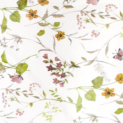 Wachstuch-Tischdecke mit floralem Muster aus zarten Blüten, grünen Blättern und Schmetterlingen auf hellem Hintergrund