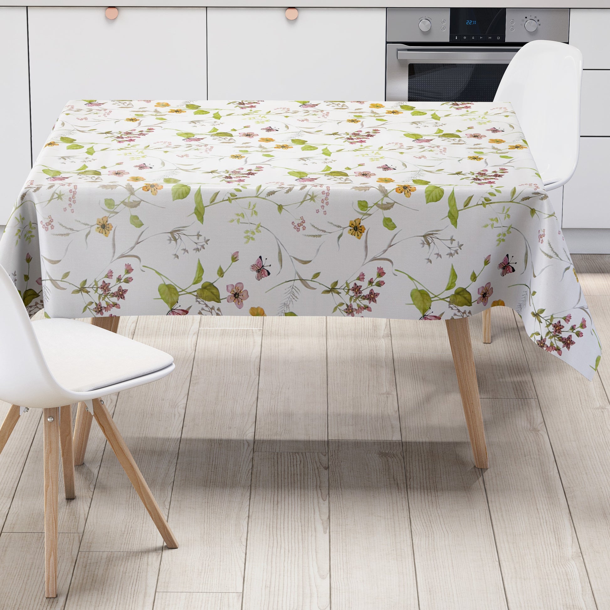 Wachstuch-Tischdecke mit floralem Muster aus zarten Blüten, grünen Blättern und Schmetterlingen auf hellem Hintergrund