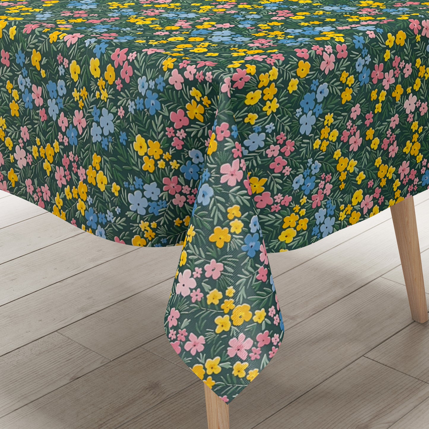 Dunkelgrüne Wachstuch-Tischdecke mit buntem Streublumenmuster aus kleinen gelben, rosa und blauen Blüten sowie feinen grünen Blättern, die über die gesamte Oberfläche verteilt sind.