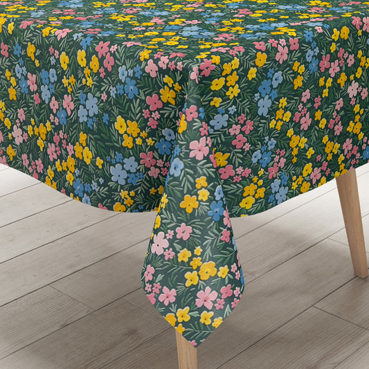 Dunkelgrüne Wachstuch-Tischdecke mit buntem Streublumenmuster aus kleinen gelben, rosa und blauen Blüten sowie feinen grünen Blättern, die über die gesamte Oberfläche verteilt sind.