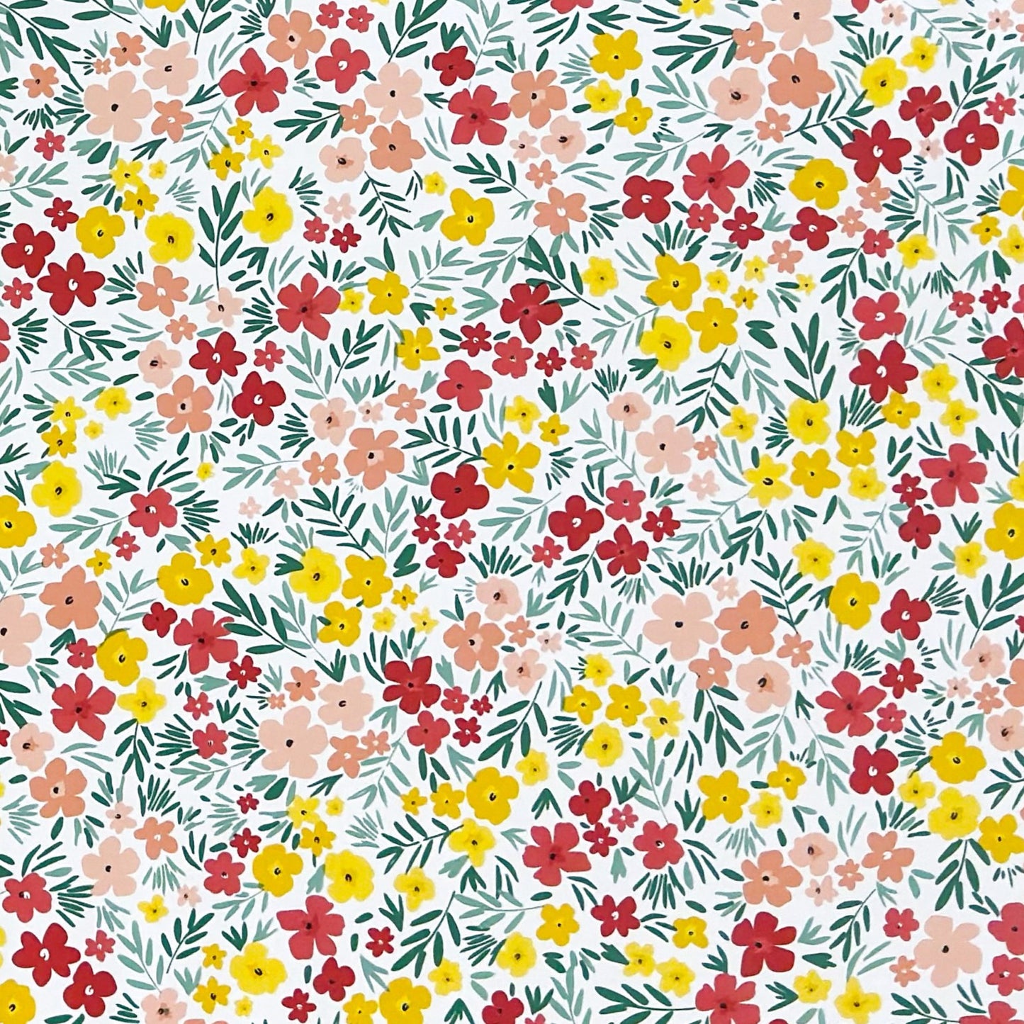 Bunte Wachstuch-Tischdecke mit dichtem Streublumenmuster in Rot, Gelb und Rosa sowie grünen Blättern auf hellem Hintergrund, über eine rechteckige Tischkante drapiert.