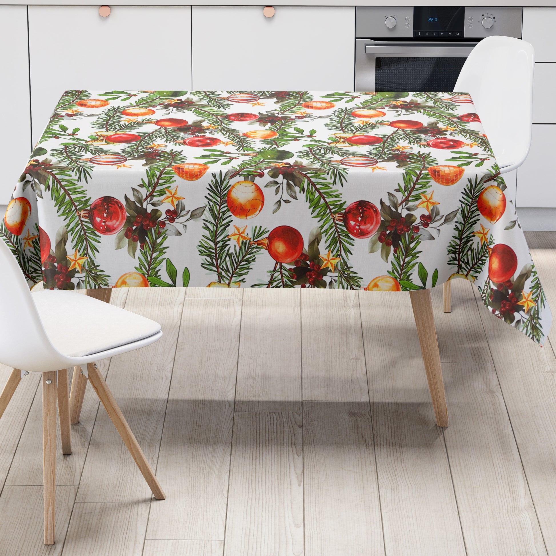 Weihnachtliche Wachstuch-Tischdecke auf weißem Hintergrund mit locker angeordneten grünen Tannenzweigen, roten, goldenen und grünen Christbaumkugeln sowie kleinen Beeren und Sternen im handgemalten Stil.