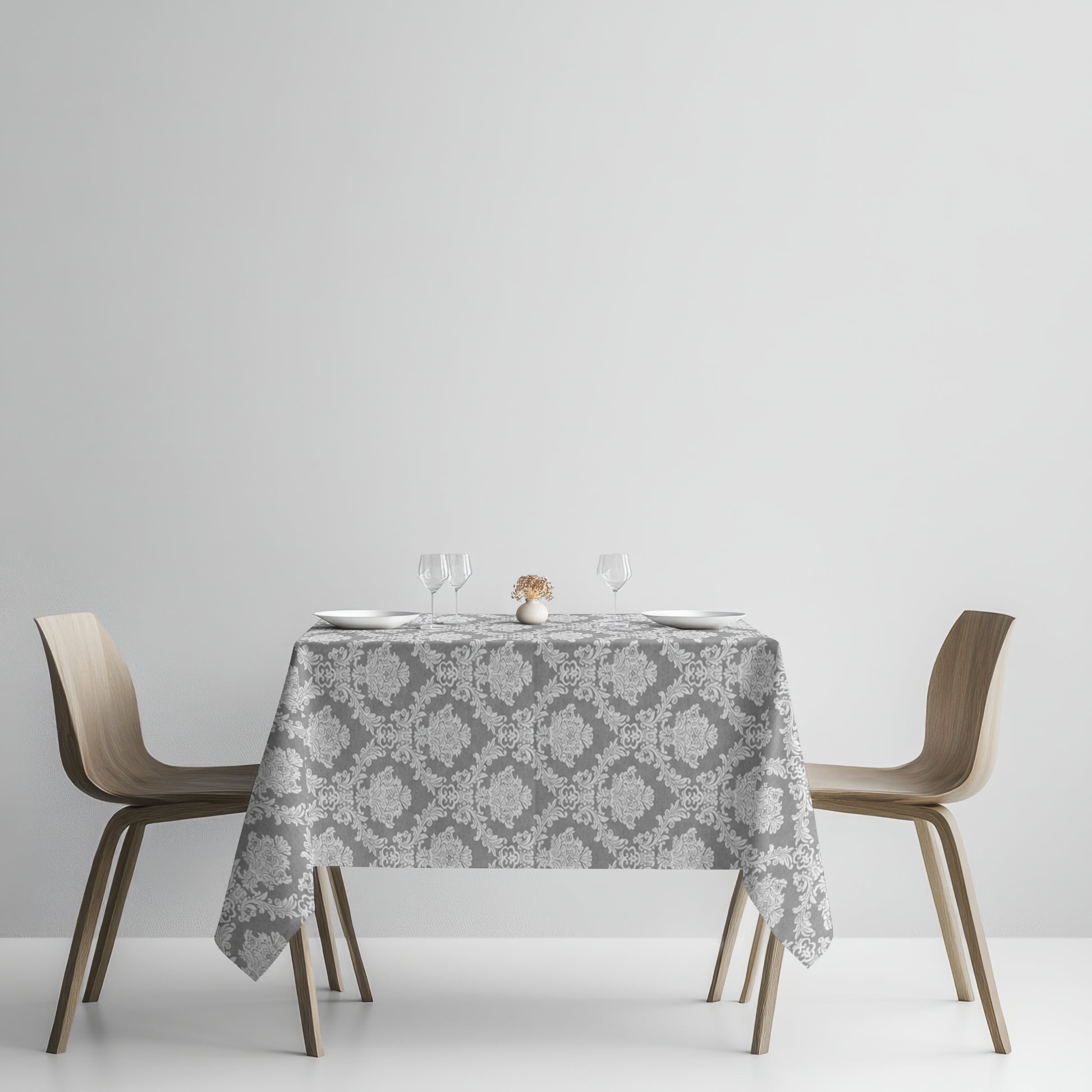 Detailaufnahme einer anthrazitfarbenen Jacquard-Tischdecke mit klassischem Ornamentmuster, beschichteter Baumwolle und Fleckenschutz.