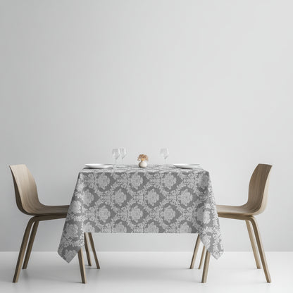 Detailaufnahme einer anthrazitfarbenen Jacquard-Tischdecke mit klassischem Ornamentmuster, beschichteter Baumwolle und Fleckenschutz.