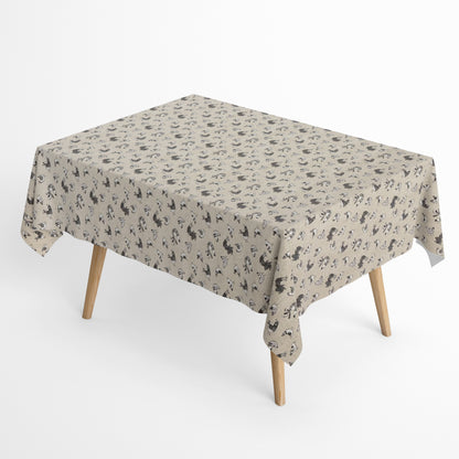 Beschichtete Baumwoll-Tischdecke mit Fleckenschutz im Design FILLOL, naturfarbener Hintergrund mit einem verspielten Allover-Muster aus stilisierten Hühnern und Küken in Schwarz- und Grautönen im skandinavischen Landhausstil.