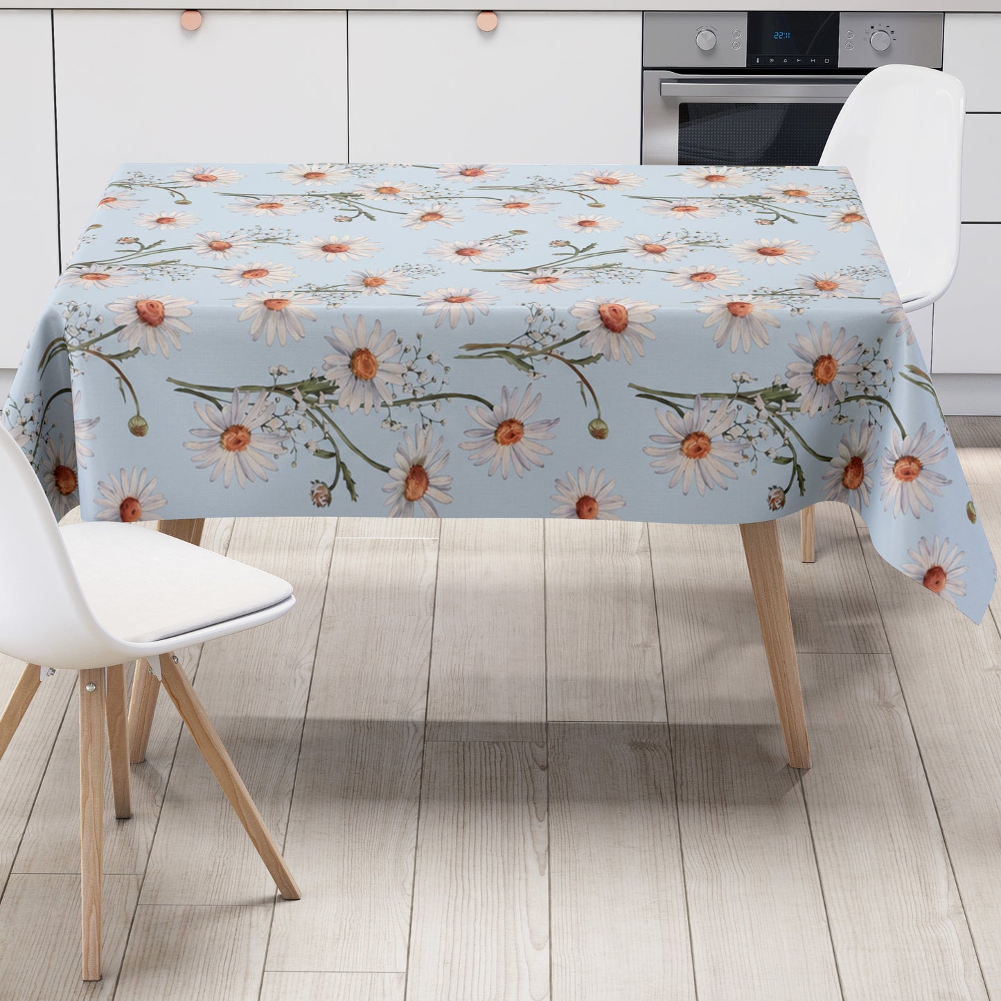 Wachstuch-Tischdecke mit weißen Margeriten und feinem Schleierkraut auf hellblauem Hintergrund. Orangefarbene Blütenmitten und grüne Stiele ergänzen das zarte, frische Blumenmuster mit sommerlicher Ausstrahlung.