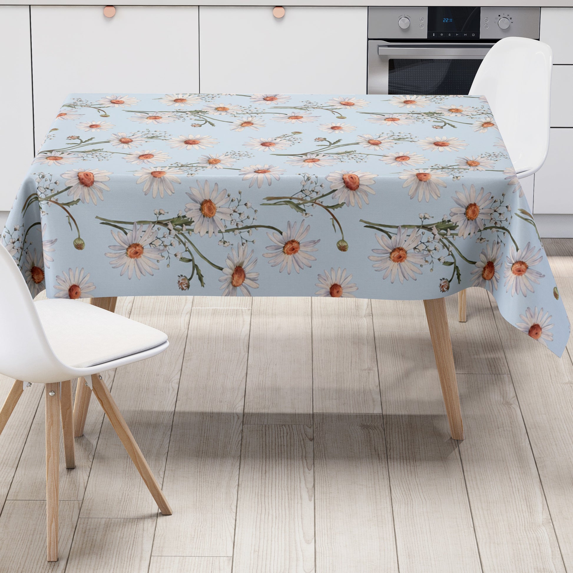 Wachstuch-Tischdecke mit weißen Margeriten und feinem Schleierkraut auf hellblauem Hintergrund. Orangefarbene Blütenmitten und grüne Stiele ergänzen das zarte, frische Blumenmuster mit sommerlicher Ausstrahlung.