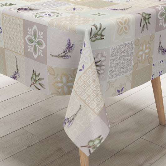 Wachstuch-Tischdecke mit Patchwork-Muster in Creme, Beige und Grau. Dekorative Fliesenornamente, stilisierte Blüten, Lavendel- und Olivenzweige in sanften Grün- und Lilatönen verleihen dem Design einen mediterranen Landhaus-Charme.