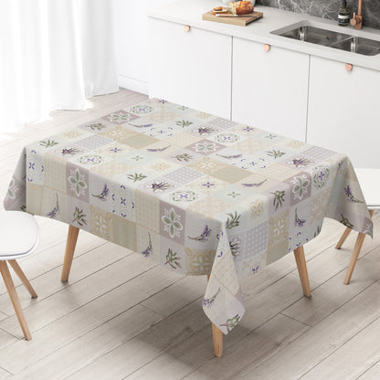 Wachstuch-Tischdecke mit Patchwork-Muster in Creme, Beige und Grau. Dekorative Fliesenornamente, stilisierte Blüten, Lavendel- und Olivenzweige in sanften Grün- und Lilatönen verleihen dem Design einen mediterranen Landhaus-Charme.