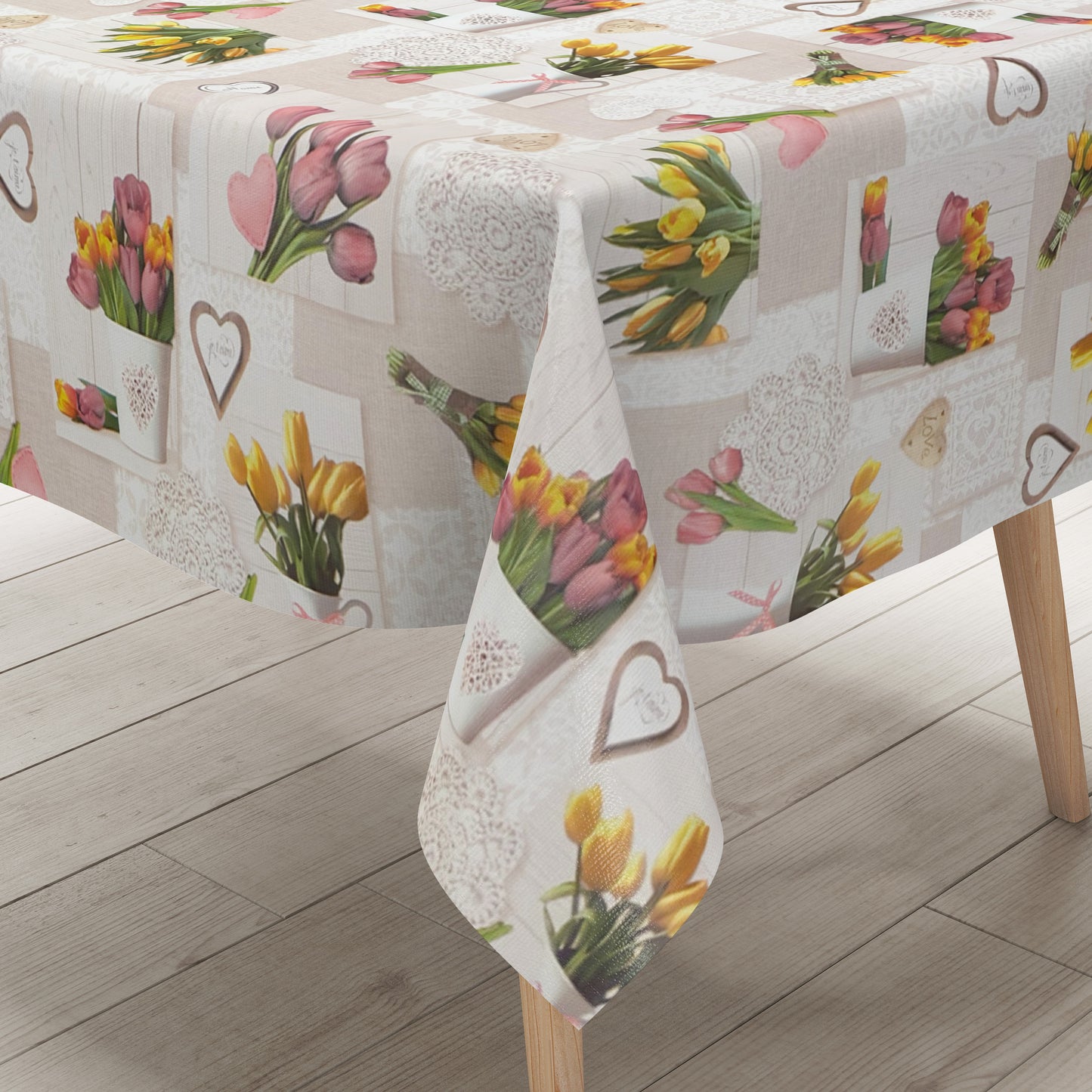 Rechteckige Wachstuch-Tischdecke in Beige und Creme mit romantischem Patchwork-Dessin. Das Muster zeigt rosa und gelbe Tulpensträuße, Herzen, Spitzenornamente und dekorative Landhaus-Elemente auf hellen Holzoptik-Hintergründen. Die frühlingshafte Farbgestaltung verleiht der Tischdecke einen gemütlichen Vintage-Charakter.