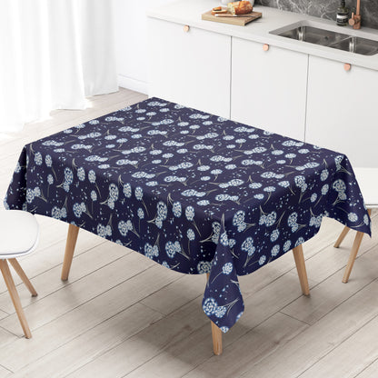 Wachstuch Tischdecke mit dunkelblauem Hintergrund und filigranen weißen Pusteblumen, deren zarte Samen wie kleine Sterne über die Fläche schweben. Ein luftiges, romantisches Blumenmuster, das an eine sommerliche Wiese im Abendlicht erinnert.