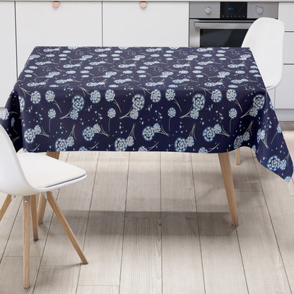 Wachstuch Tischdecke mit dunkelblauem Hintergrund und filigranen weißen Pusteblumen, deren zarte Samen wie kleine Sterne über die Fläche schweben. Ein luftiges, romantisches Blumenmuster, das an eine sommerliche Wiese im Abendlicht erinnert.