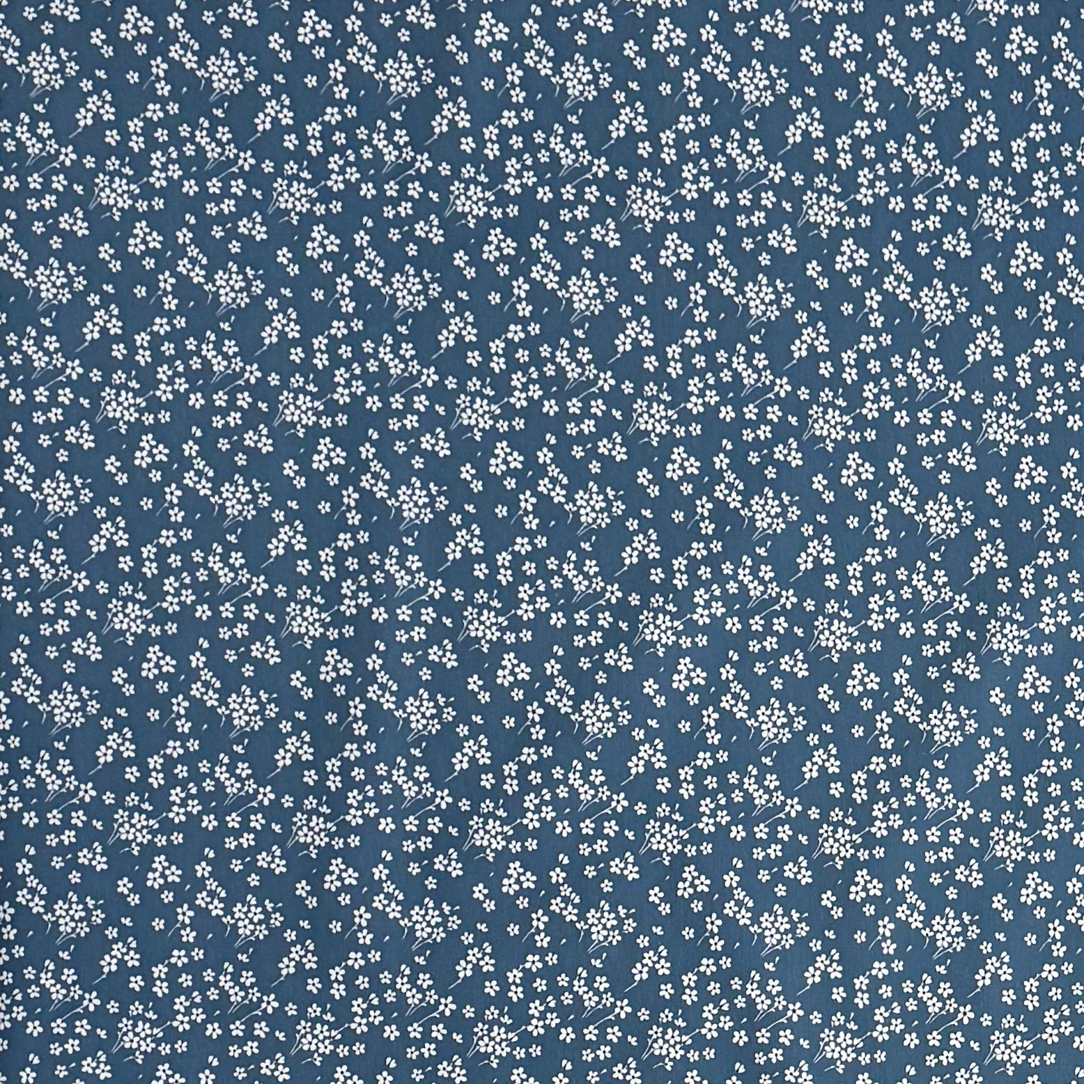 Die Jacquard Tischdecke aus beschichteter Baumwolle zeigt ein dezentes Streublumenmuster mit vielen kleinen, feinen Blüten in Weiß auf dunklem Hintergrund. Die gleichmäßige Verteilung wirkt ruhig und elegant.
