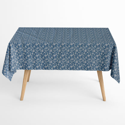 Die Jacquard Tischdecke aus beschichteter Baumwolle zeigt ein dezentes Streublumenmuster mit vielen kleinen, feinen Blüten in Weiß auf dunklem Hintergrund. Die gleichmäßige Verteilung wirkt ruhig und elegant.