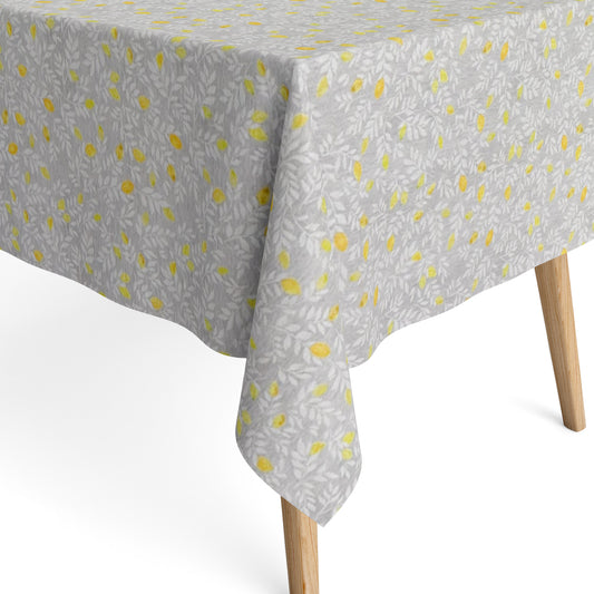 Die Jacquard Tischdecke aus beschichteter Baumwolle zeigt ein feines, dichtes Allover-Muster aus kleinen Zitronen und zarten Blättern in Gelb- und Grautönen.