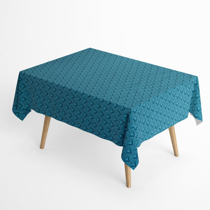 Die Jacquard Tischdecke aus beschichteter Baumwolle zeigt ein modernes, geometrisches Muster aus feinen, fächerartigen Kreisen in Petrol- und Blautönen.