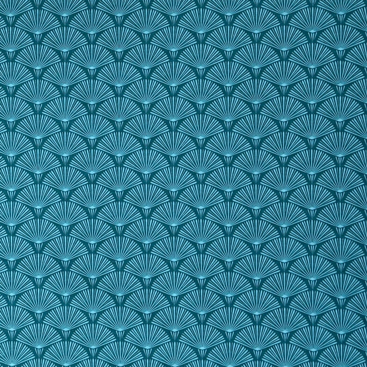 Die Jacquard Tischdecke aus beschichteter Baumwolle zeigt ein modernes, geometrisches Muster aus feinen, fächerartigen Kreisen in Petrol- und Blautönen.