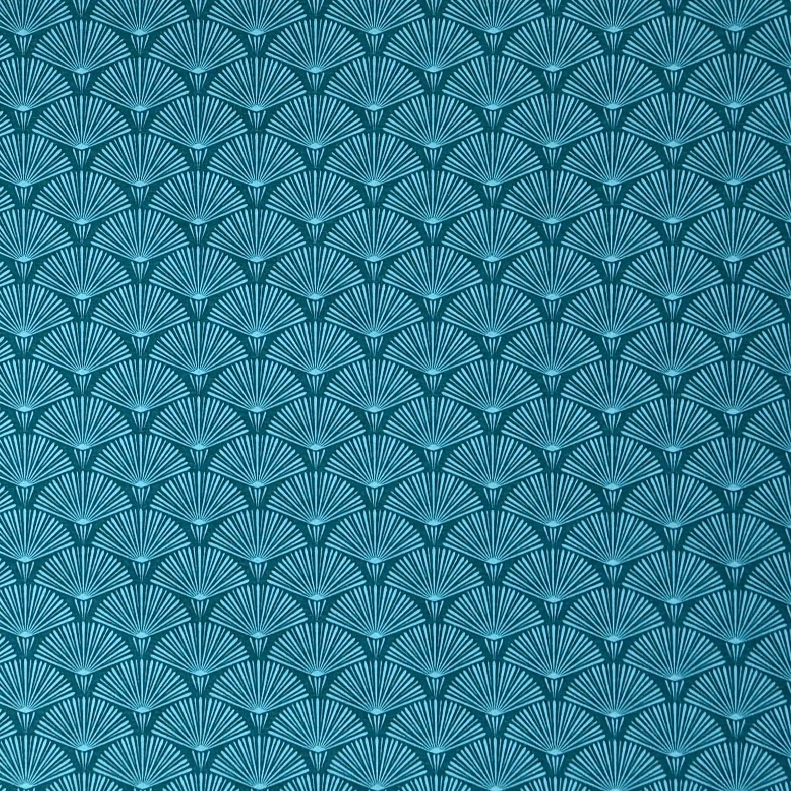 Die Jacquard Tischdecke aus beschichteter Baumwolle zeigt ein modernes, geometrisches Muster aus feinen, fächerartigen Kreisen in Petrol- und Blautönen.